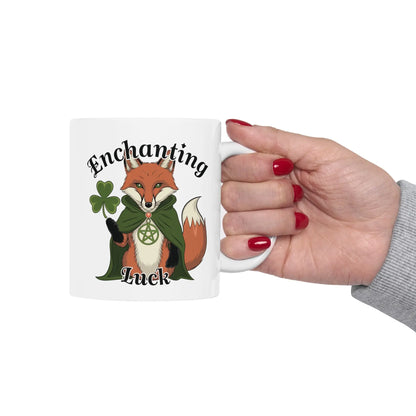 Person holding the white fox mug, showcasing the side of the mug featuring a mystical pagan fox adorned with clovers and a pentagram necklace.