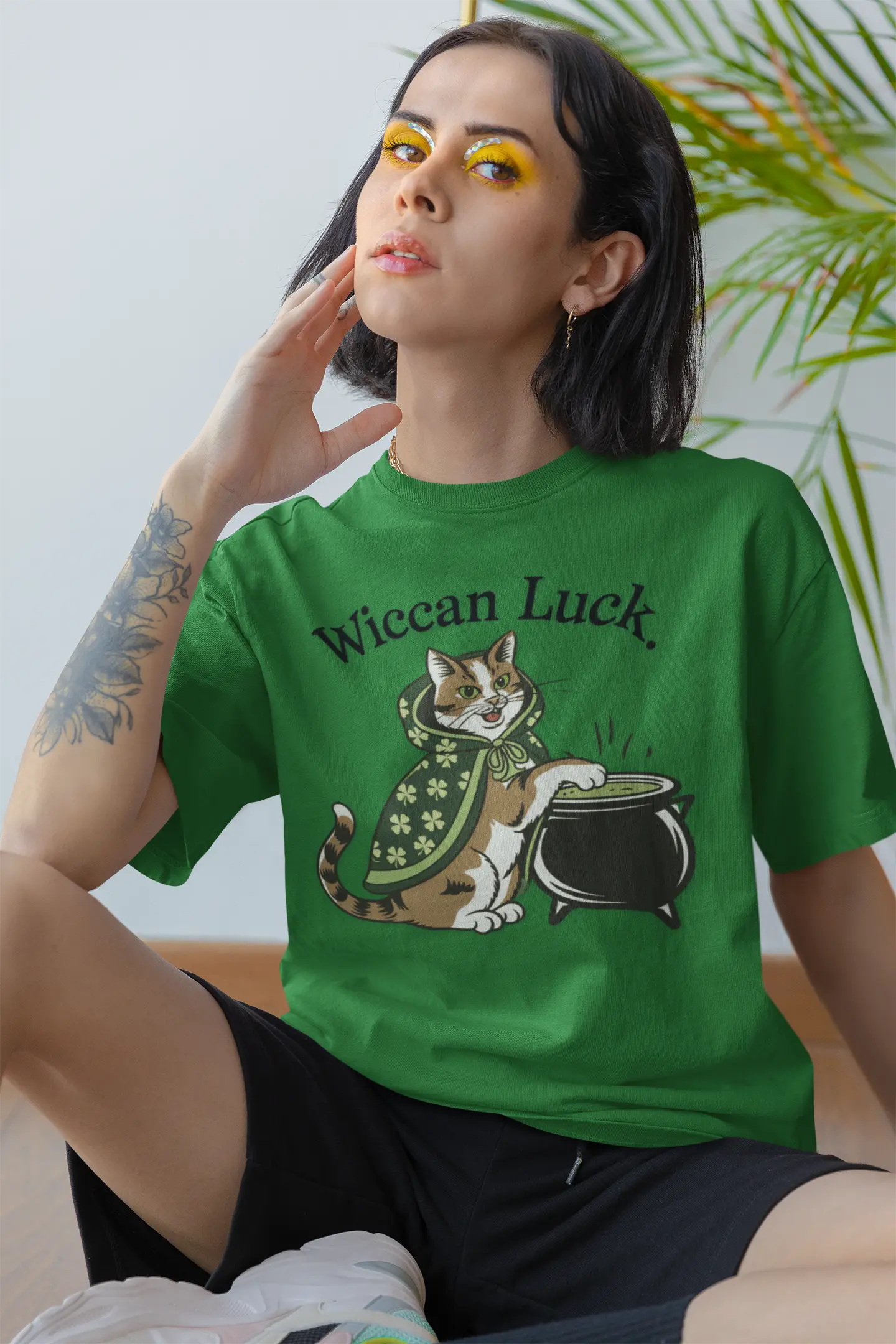 Lady wearing an Irish green tee featuring the lucky cat design with St. Patty's Day 4-leaf clover robe and witch's cauldron - witchypets.com